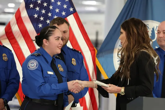 Kristi Noem gives a bonus check to a TSA agent.