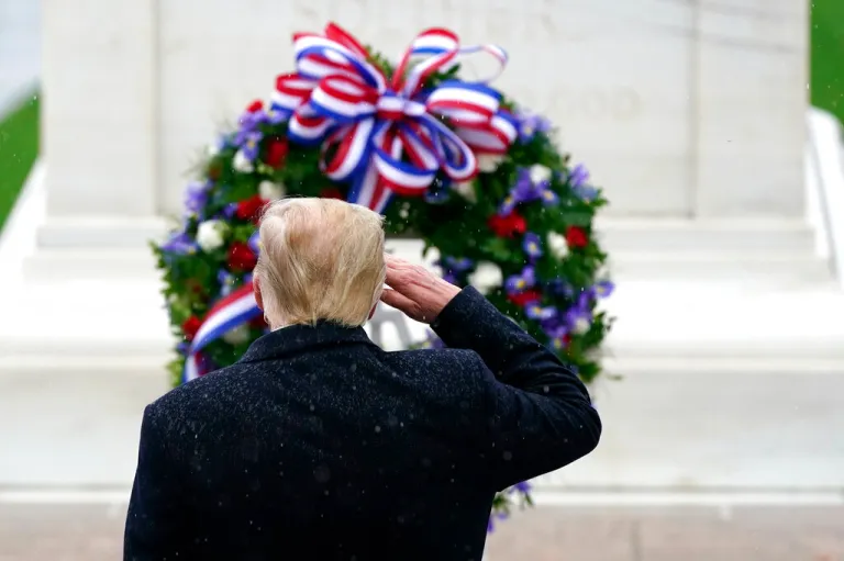 Trump salutes as he participates in a Veterans Day wreath-laying ceremony
