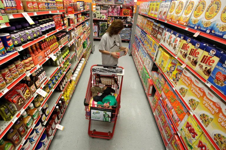 A woman looks at products in the aisle of a store.