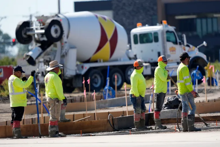 FILE - Construction crew members wait to pour concrete in a parking lot on Sept. 4, 2024, in Waukee, Iowa.