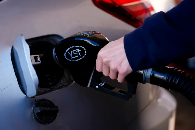 A driver fills up their car at a gasoline pump.