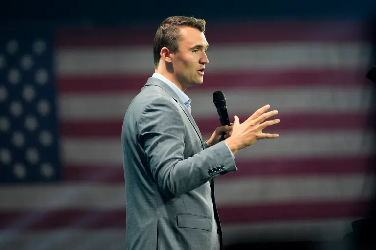 Turning Point USA co-founder Charlie Kirk speaks into a microphone onstage.