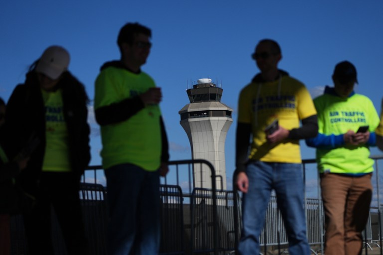 Air Traffic Controllers stand outside distributing leaflets explaining how the federal government shutdown is impacting air travel at Detroit Metropolitan Wayne County Airport in Romulus, Mich., Oct. 28, 2025.