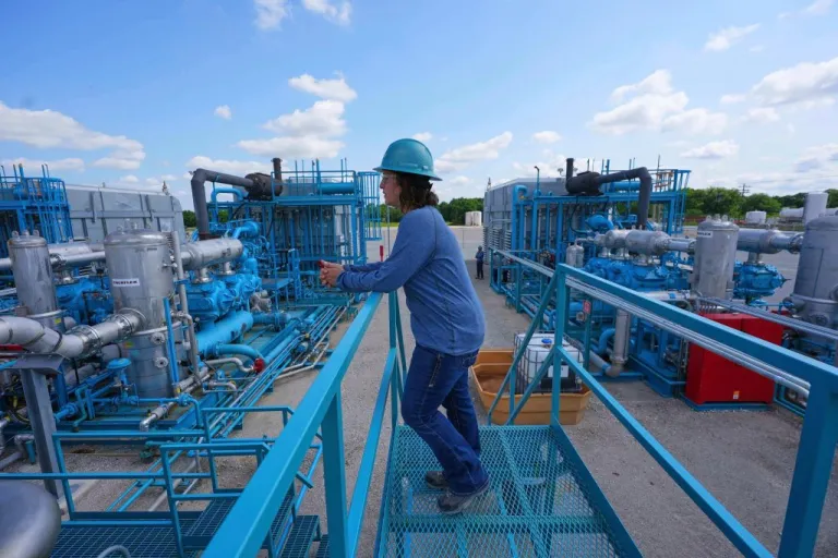 BKV Carbon Ventures senior facility engineer Laura Mamazza stands near part of a compression station at a carbon capture and sequestration facility in Bridgeport, Texas