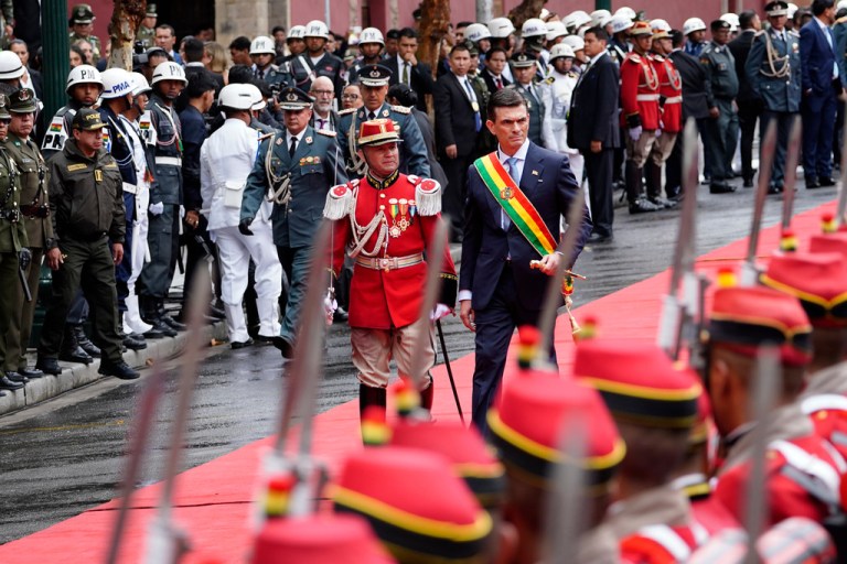 President Rodrigo Paz walks in front of military servicemen following swearing-in ceremony