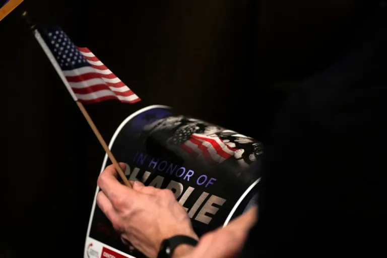 A supporter holds a memorial poster for Charlie Kirk at 