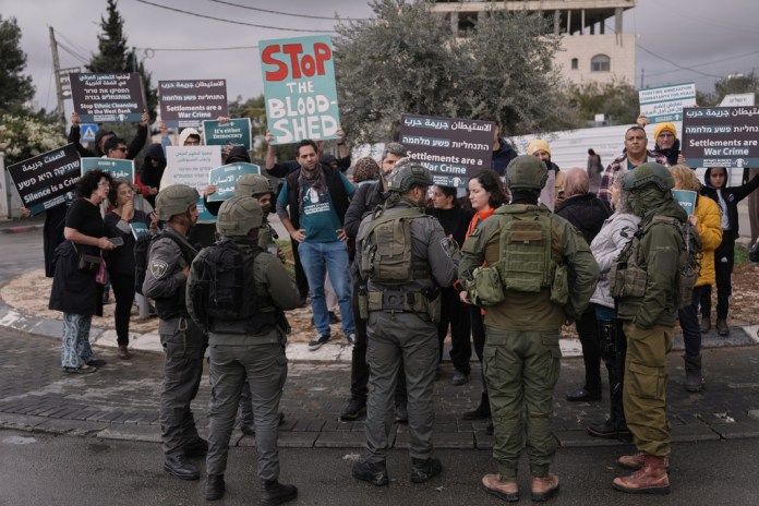 Palestinian and Israeli activists take part in a protest against Israeli settlers' violence as they gather in the West Bank town of Beit Jala.