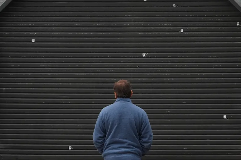 A man looks toward bullet holes where a mass shooting took place Saturday at a banquet hall in Stockton, California.