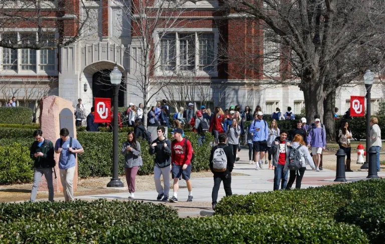 FILE - People walk on the Oval at the University of Oklahoma in Norman, Okla., Tuesday, March 10, 2015. (AP Photo/Sue Ogrocki, File)