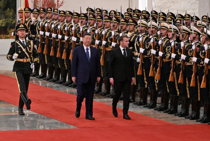 Macron and Xi walk past a Chinese military honor guard in Beijing