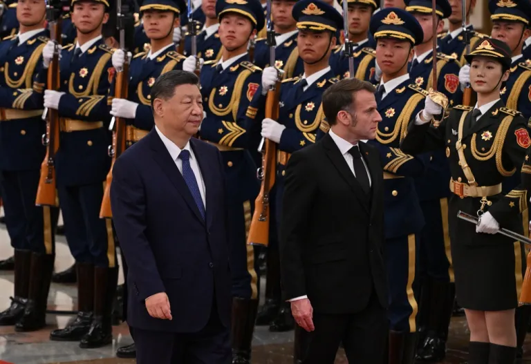 Macron and Xi walk past a Chinese military honor guard in Beijing