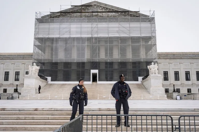 U.S. Supreme Court police officers stand in front of the Supreme Court amid renovations as the justices hear oral arguments on President Donald Trump's push to expand control over independent federal agencies, on Capitol Hill in Washington, Monday, Dec. 8, 2025. (AP Photo/J. Scott Applewhite)