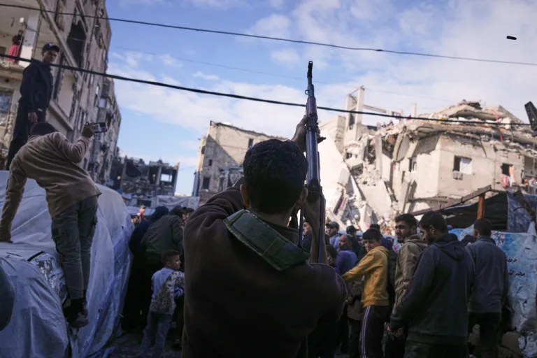 A Palestinian man fires in the air during a funeral.