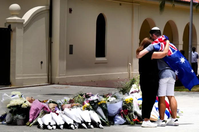 A couple lay flowers at a tribute to victims of the Bondi Beach shooting in Australia.
