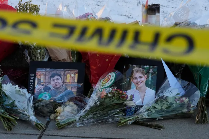 Photos of Brown University shooting victims Mukhammad Aziz Umurzokov, left, and Ella Cook, are seen amongst flowers at a makeshift memorial