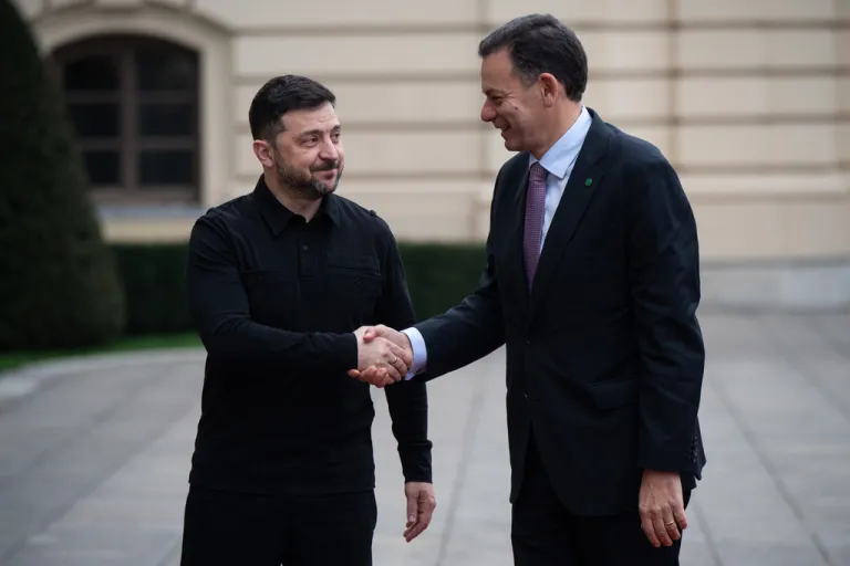 Ukrainian President Volodymyr Zelensky shakes hands with Portuguese Prime Minister Luís Montenegro.