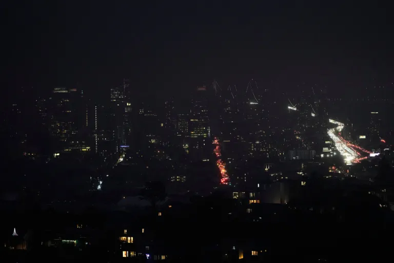Fog and power outages darken the skyline as traffic moves in San Francisco