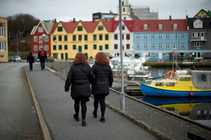 Two women walk beside the harbor in Torshavn, the capital city of the Faeroe Islands.