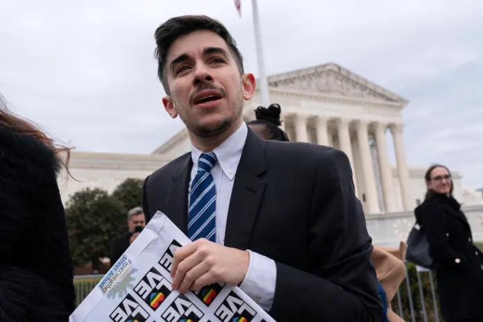 Attorney and transgender rights activist Chase Strangio speaks to supporters outside of the Supreme Court.