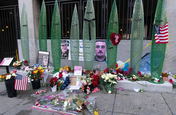A makeshift memorial of flags, flowers and other items are displayed outside of Farragut West Station on Dec. 1, near the site where two National Guard members were shot in Washington on Nov. 26. (Jose Luis Magana/AP)