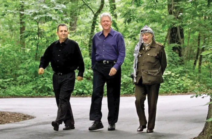 From left, Israeli Prime Minister Ehud Barak, President Bill Clinton, and Palestinian leader Yasser Arafat take a break  from negotiations to stroll the grounds of Camp David, Maryland, July 11, 2000. (Ron Edmonds/AP)