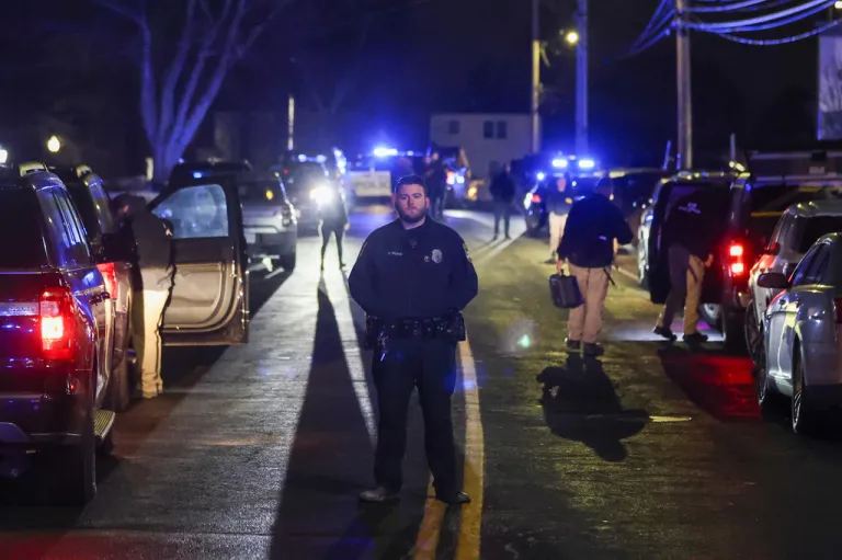 Law enforcement officers stand outside a storage facility where a suspect in the shooting at Brown University was found dead.