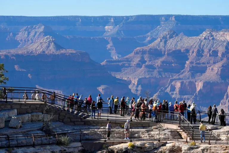 Tourists look at the Grand Canyon.