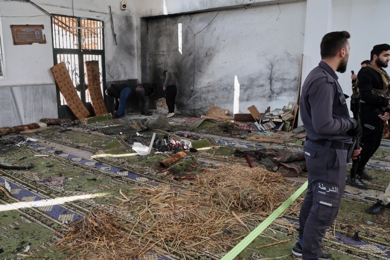 Syrian security forces inspect the damage after an explosion.