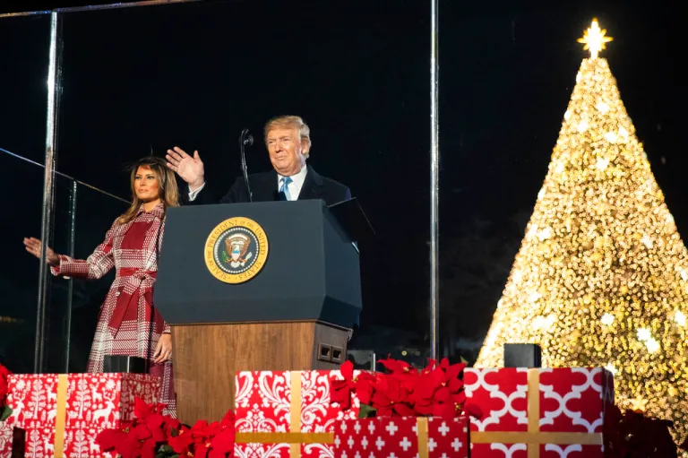 President Donald Trump and first lady Melania Trump wave during the National Christmas Tree Lighting ceremony.