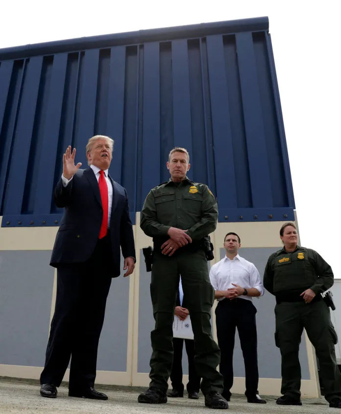 President Donald Trump speaks during a tour as he reviews border wall prototypes, Tuesday, March 13, 2018, in San Diego, as Rodney Scott, the Border Patrol's San Diego sector chief, listens. (AP Photo/Evan Vucci)