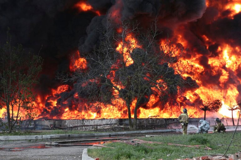 Donetsk People Republic Emergency Situations Ministry firefighters work at the site of fire at the oil depot after missiles struck the facility in an area controlled by Russian-backed separatist forces in Makiivka, 15 km (94 miles) east of Donetsk, eastern Ukraine, Wednesday, May 4, 2022. The representative office of the Donetsk People's Republic in the Joint Center for Control and Coordination of the ceasefire regime (JCCC) said on Wednesday that the city of Makiivka was shelled and, according to preliminary data, an oil depot was on fire.