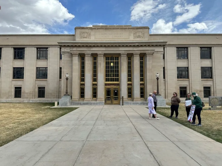 Demonstrators stand before the Wyoming Supreme Court building in Cheyenne ahead of arguments over the state's abortion bans Wednesday, April 16, 2025.