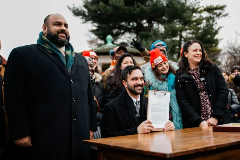 New York City Mayor Zohran Mamdani, center, joined by Ali Najmi, left, chair of the Mayor's Advisory Committee on the Judiciary, and Tascha Van Auken, right, commissioner of the Mayor's Office of Mass Engagement, holds up a signed executive order during a press conference in New York, Friday, Jan. 2, 2026. (AP Photo/Eduardo Munoz Alvarez)