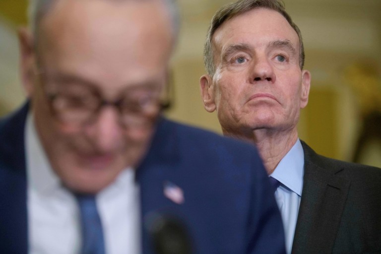 Sen. Mark Warner, D-Va., right, listens as Senate Minority Leader Chuck Schumer, D-N.Y., left, speaks during the Senate Democrat policy luncheon news conference at the Capitol, Tuesday, Jan. 6, 2026, in Washington
