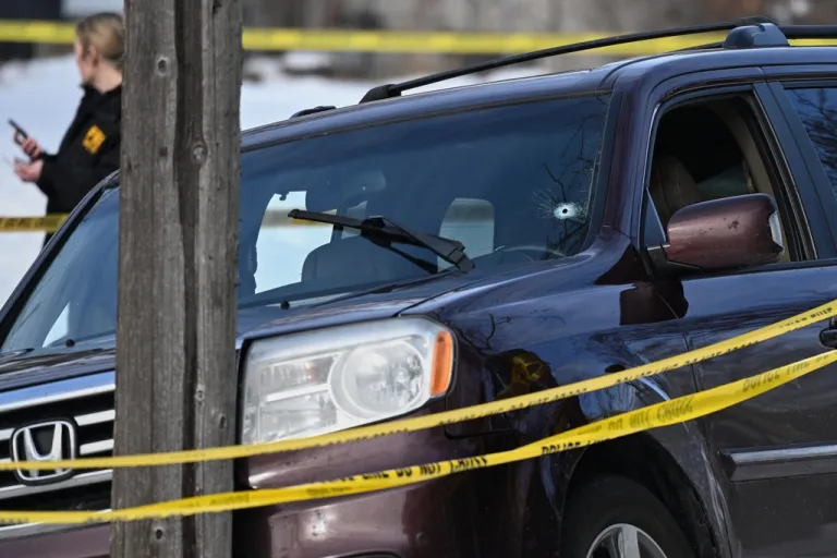 A bullet hole is seen in the windshield as law enforcement officers work at the scene of a shooting involving federal law enforcement agents, Wednesday, Jan. 7, 2026, in Minneapolis.