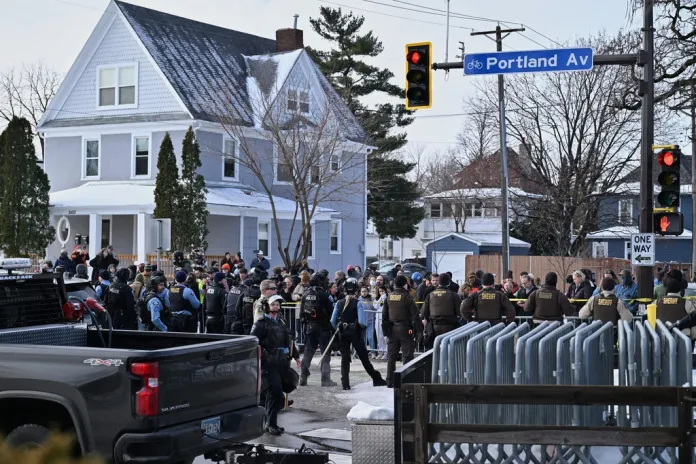 People protest as law enforcement officers attend to the scene of the shooting involving federal law enforcement agents, Wednesday, Jan. 7, 2026, in Minneapolis. 