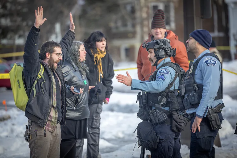 Protesters confront law enforcement agents at the scene of a shooting in Minneapolis.