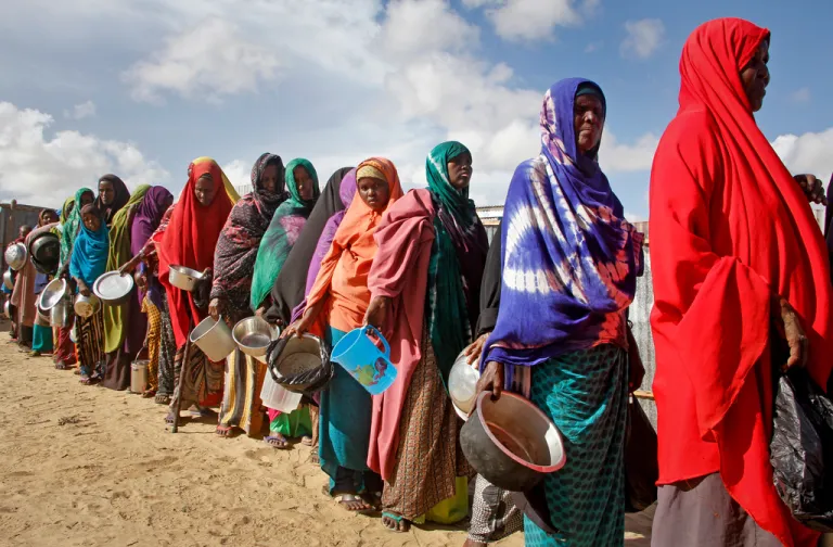 In this May 18, 2019 file photo, newly-arrived women who fled drought line up to receive food
