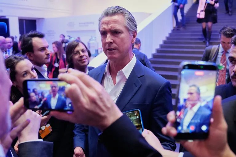 California Gov. Gavin Newsom surrounded by phones