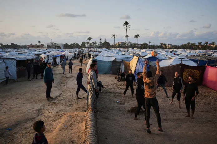 Gazan refugees play volleyball in a refugee camp