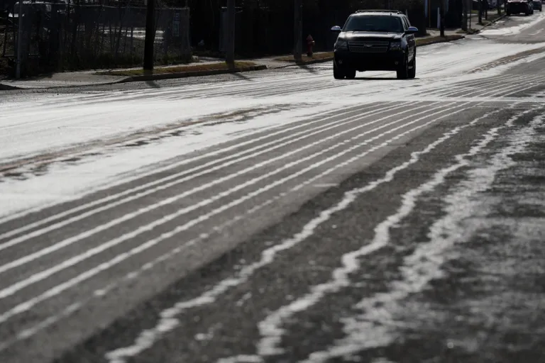 A motorist travels on a road that has been treated with salt brine.