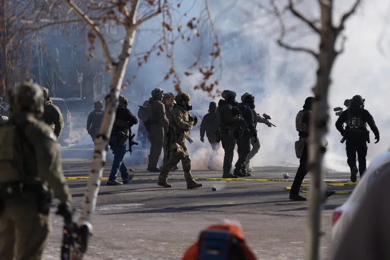 Federal immigration officers deploy tear gas at observers after a shooting Saturday, Jan. 24, 2026, in Minneapolis.
