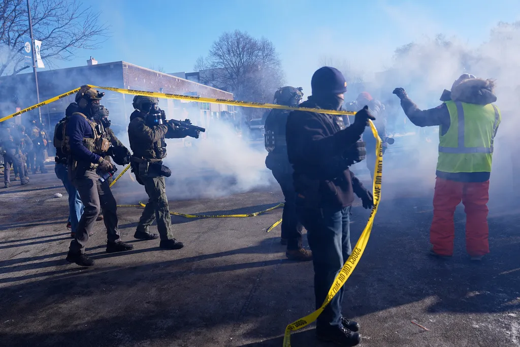 Federal immigration officers deploy tear gas at protesters after a shooting Saturday, Jan. 24, 2026, in Minneapolis.