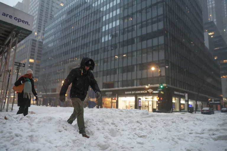 Pedestrians cross the street during a winter storm, Sunday, Jan. 25, 2026, in New York.