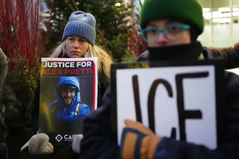 Demonstrators hold signs during a protest outside the office of Sen. Amy Klobuchar in Minneapolis