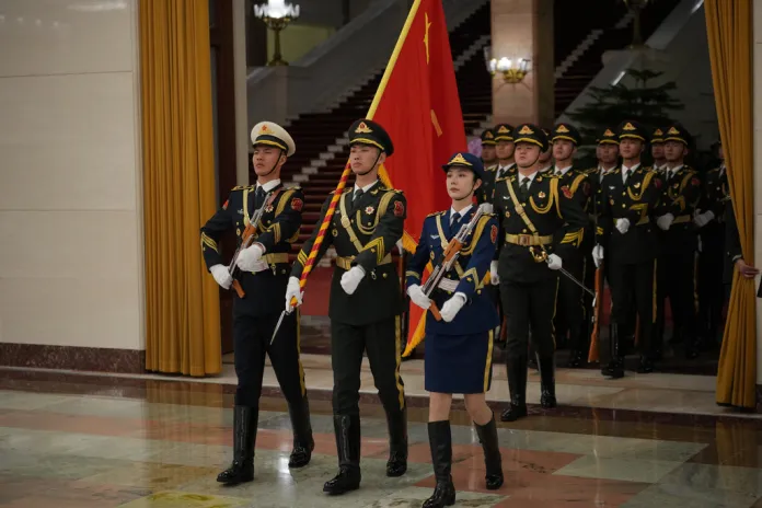 A Chinese honor guard walk through the Great Hall of the People