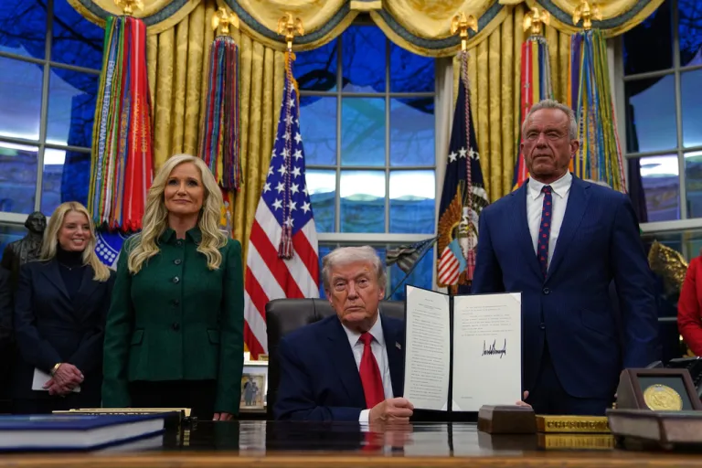 President Donald Trump holds a sign executive order on addiction recovery.