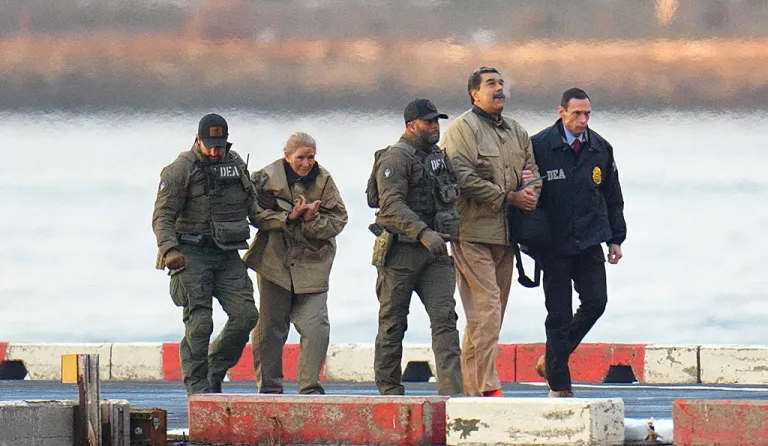 Nicolas Maduro and his wife, Cilia Flores, are seen in handcuffs after landing at a Manhattan helipad, escorted by heavily armed Federal agents as they make their way into an armored car en route to a Federal courthouse in Manhattan on January 5, 2026 in New York City. (Photo by XNY/Star Max/GC Images)