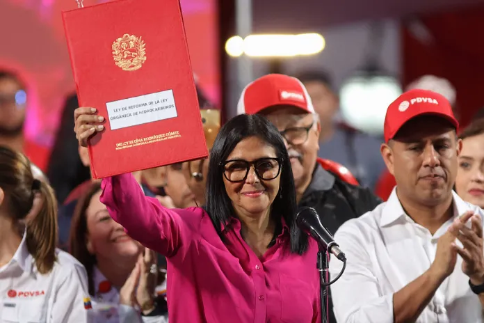 Venezuela's interim President Delcy Rodriguez holds a copy of the Reform of the Organic Law on Hydrocarbons outside the Miraflores Presidential Palace in Caracas on January 29, 2026. Venezuela adopted a reform opening its nationalized oil sector to private investment on January 29 as it moves to appease the United States following the toppling of leader Nicolas Maduro. (Photo by Pedro MATTEY / AFP via Getty Images)