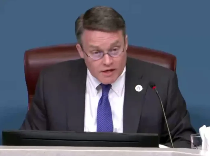 Man in chair talking into microphone